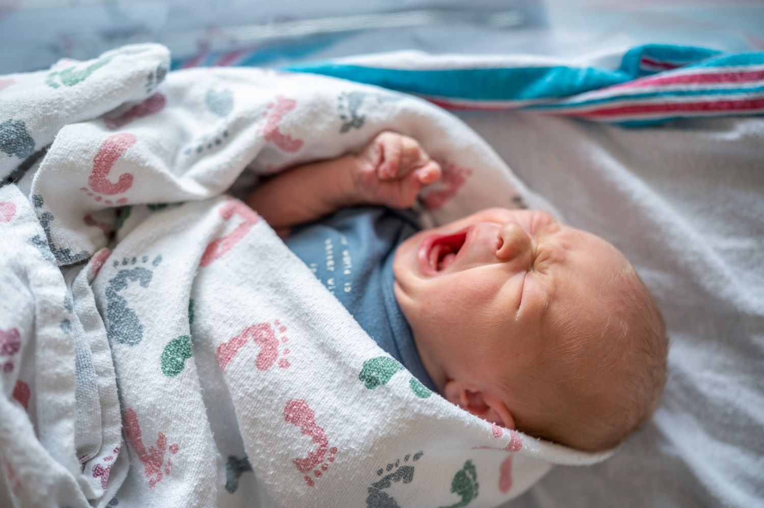 Newborn baby yawning wrapped in a blanket in the hospital at a fresh 48 photoshoot candid Brevard Melbourne Cocoa Beach Vero Florida