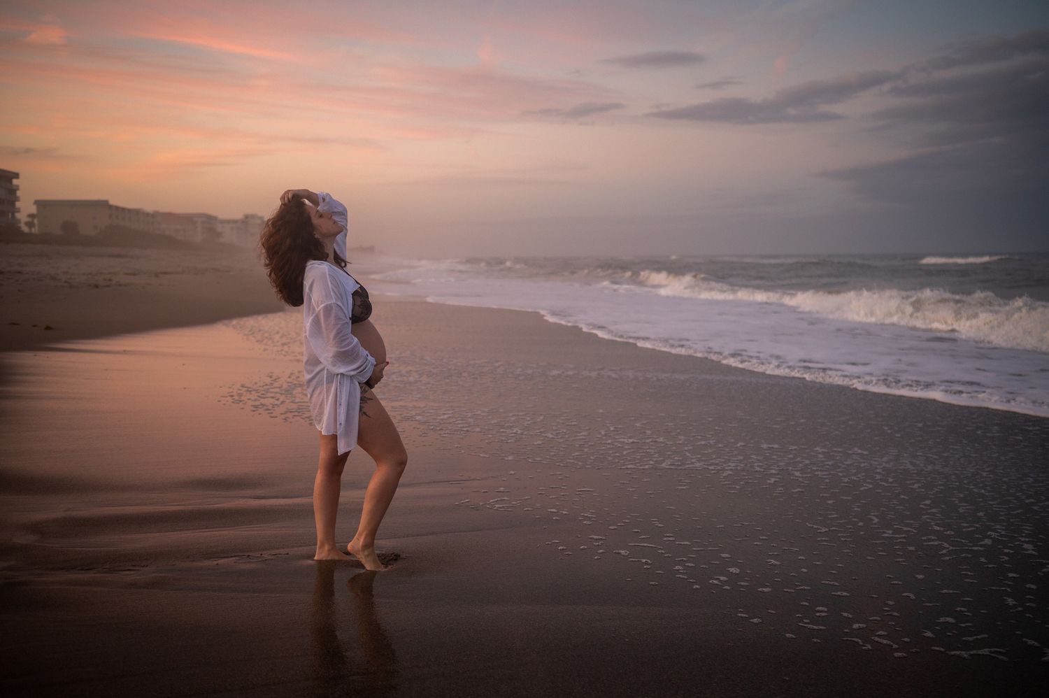Maternity session photoshoot pregnant mother standing on beach sunset candid moment Melbourne Cocoa Beach Vero Florida Brevard County