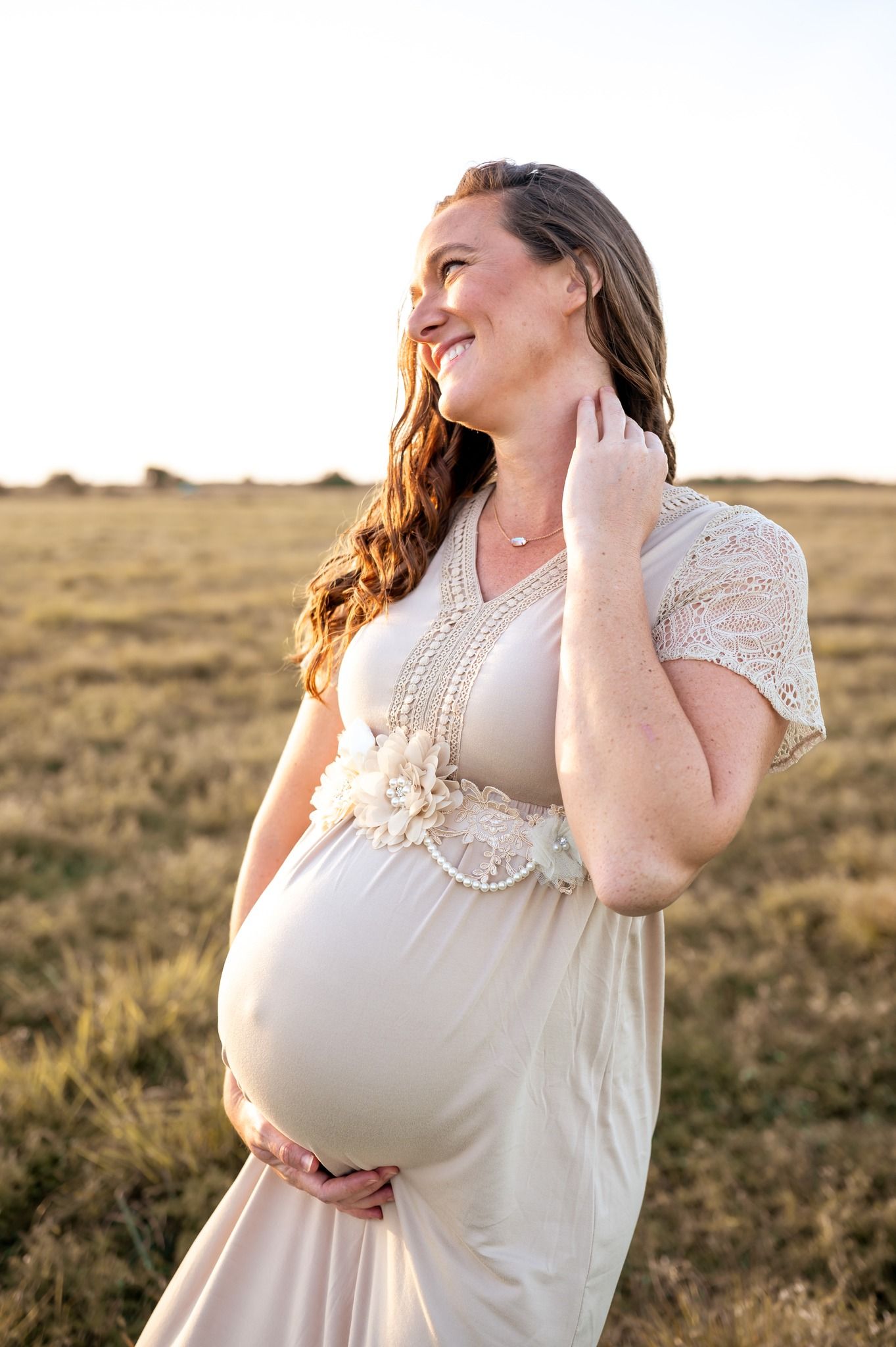 Maternity session photoshoot pregnant mother standing  grassy field sunset candid moment Melbourne Cocoa Beach Vero Florida Brevard County