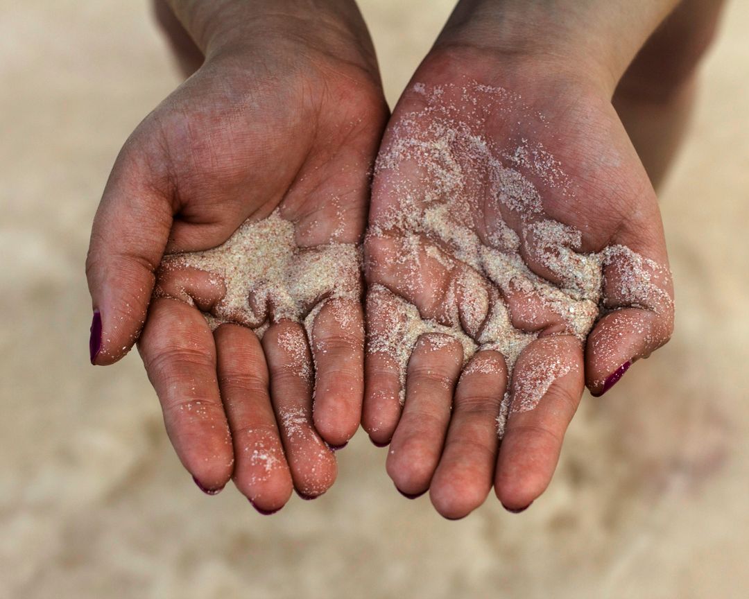 crisp image of hands holding sand