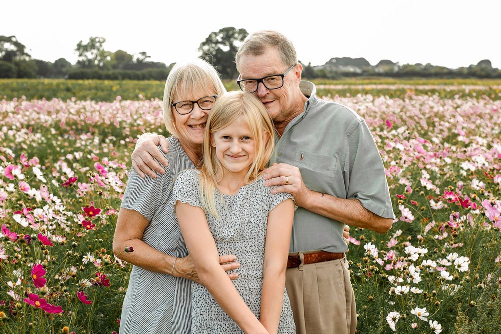 At Sam's Sunflowers on Hayling Island, Hampshire, grandparents hug their grandchildren amongst the wildflowers.