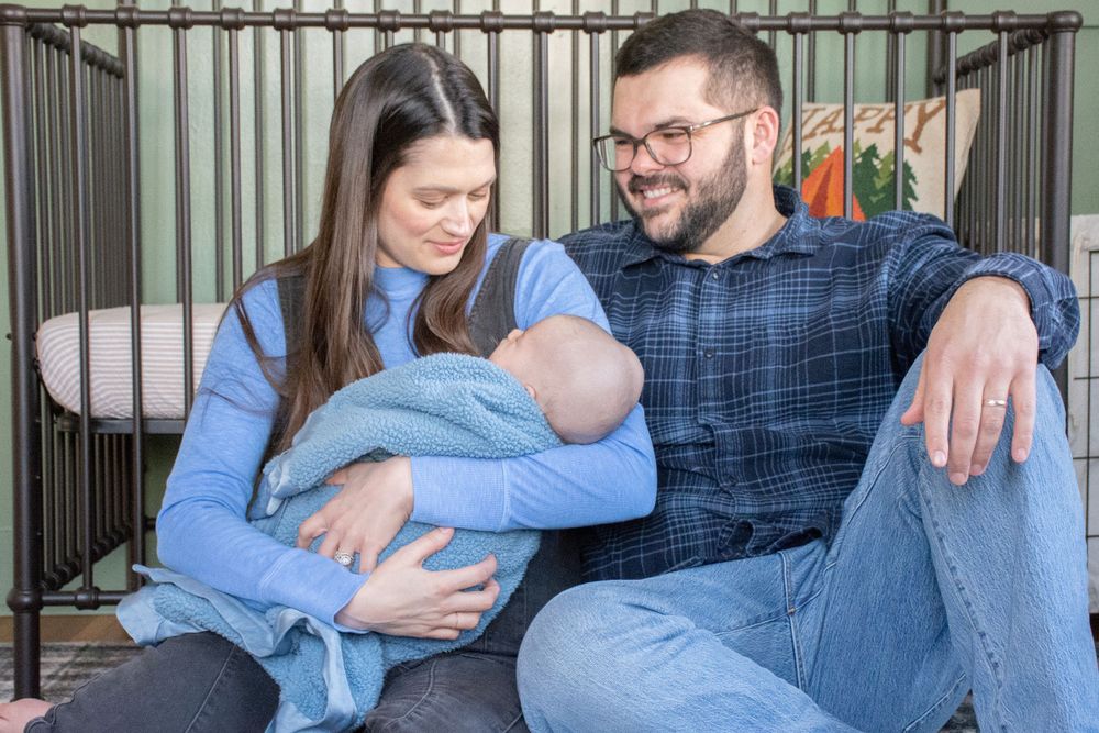a family sitting by a crib