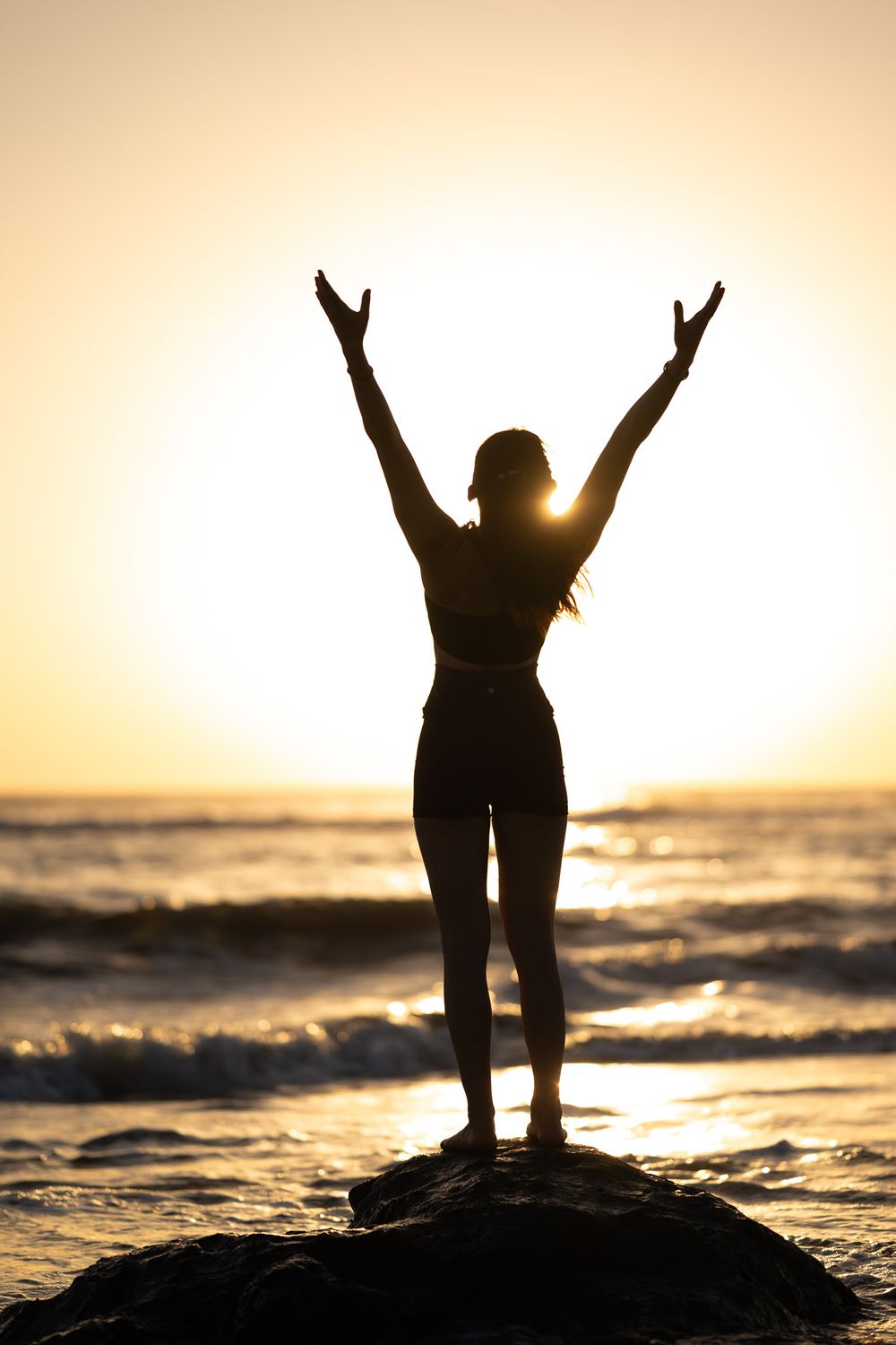 Female yoga student facing the ocean at the beach in Playa Negra Costa Rica
