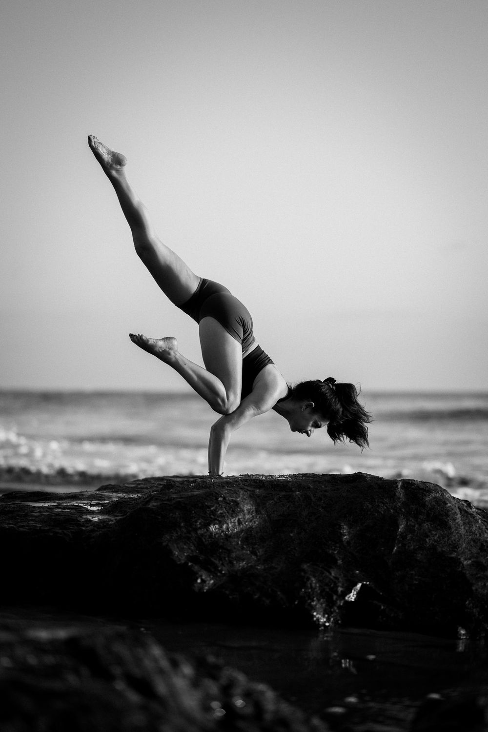 Female yoga student in a balancing yoga pose at the beach in Playa Negra Costa Rica