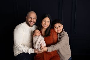 A family of four poses for a portrait. NJ newborn photographer in Sussex County NJ