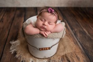 Squishy baby in a bucket for her newborn photoshoot session in New Jersey
