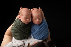 Newborn baby boy swaddled, sleeping soundly in mama's arms in New Jersey studio