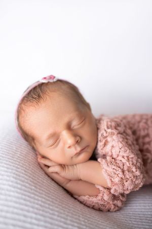 Series of newborn photography poses on soft textured blanket in delicate pink tones.