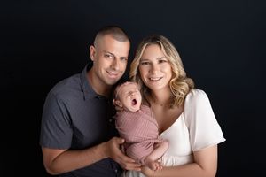 A series of black and white family portraits showing intimate moments between parents and their baby.