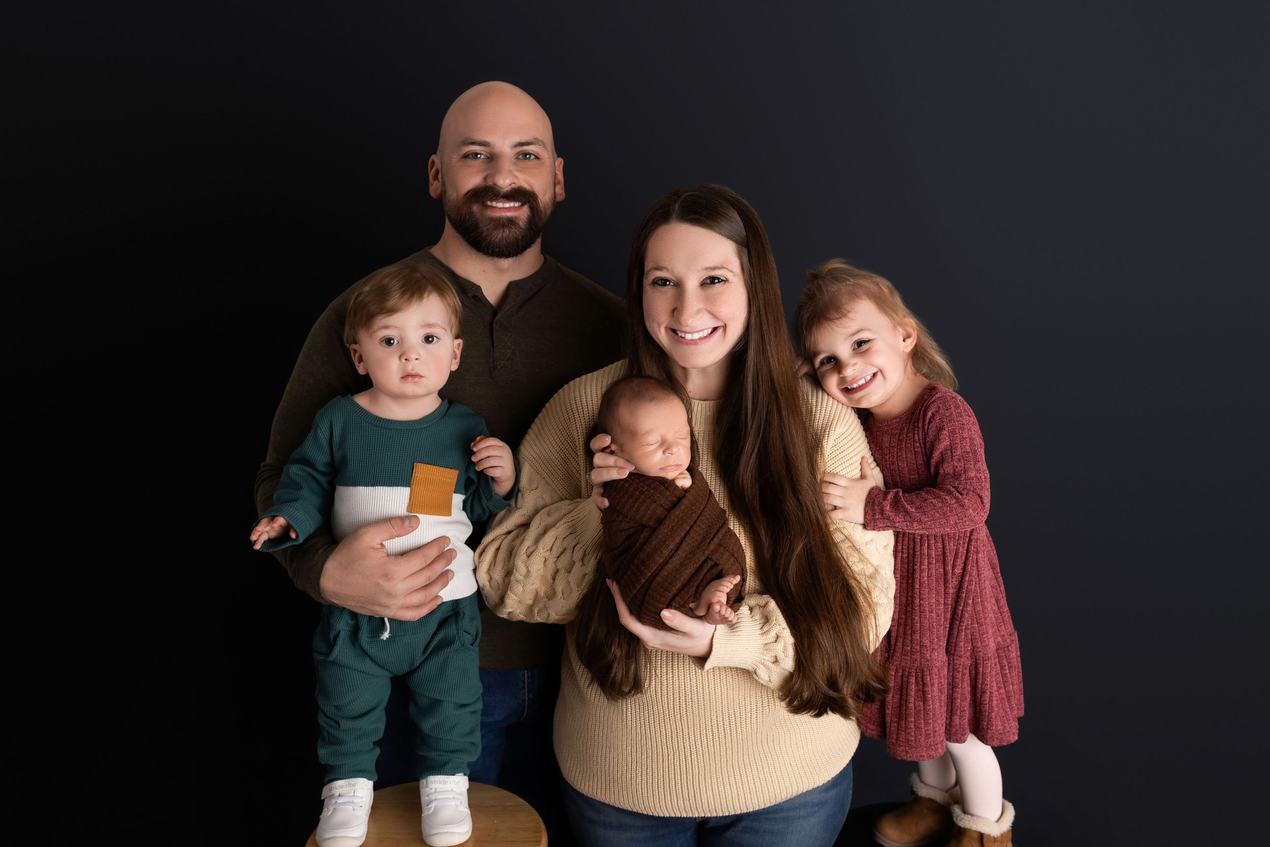 A family poses together against a dark background in a series of candid moments and expressions.