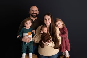 A family poses together against a dark background in a series of candid moments and expressions.