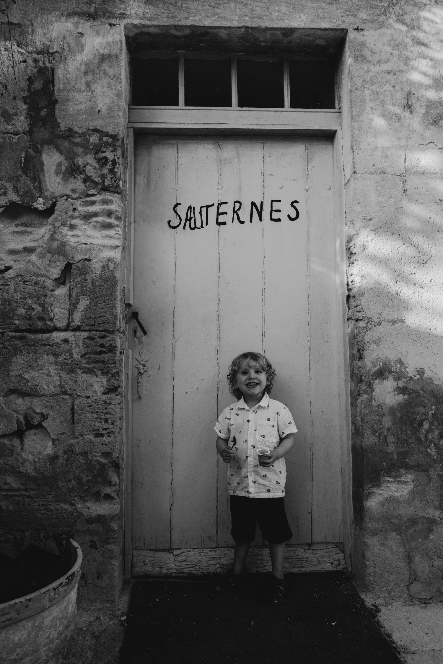boy standing by an old door in France