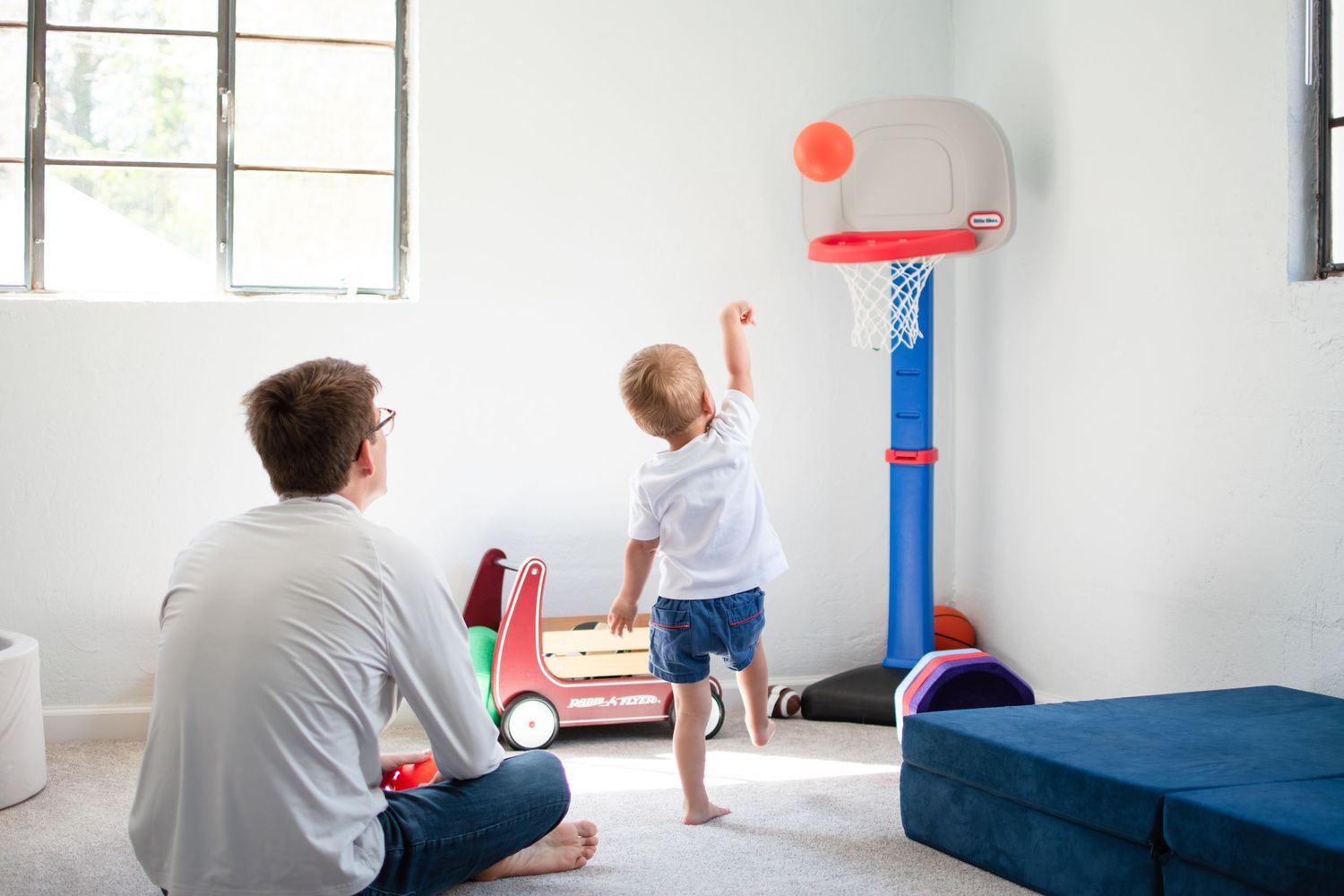 A boy and his dad play basketball in their Ardmore basement in Winston-Salem.