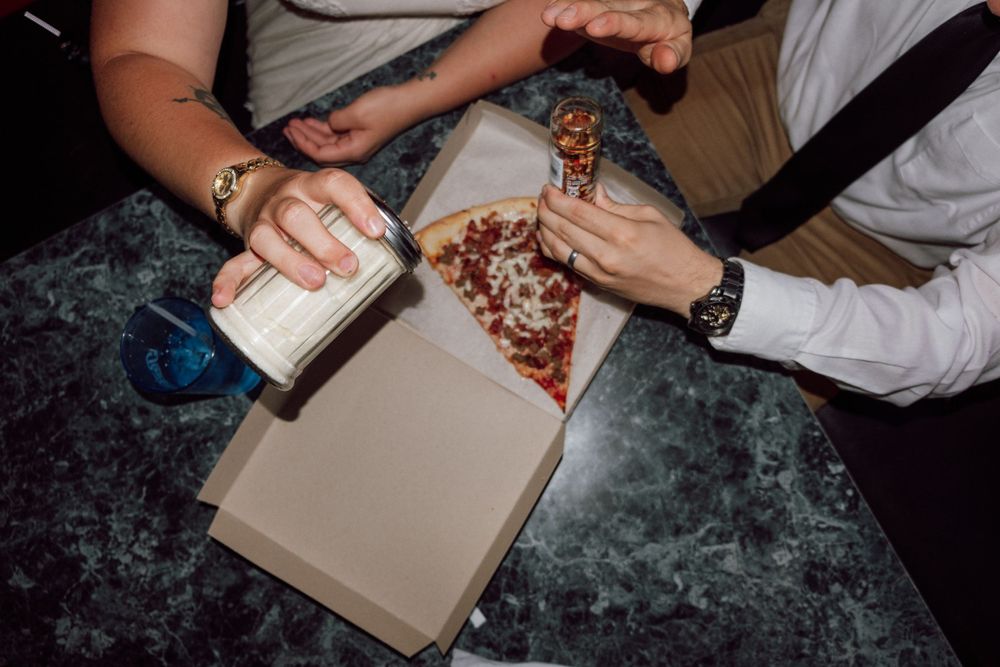 bride and groom eating pizza in virginia beach, virginia pizzeria