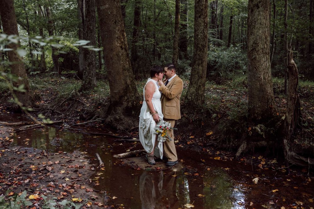 bride and groom standing in creek elopement in the forest in virginia beach wedding photographer