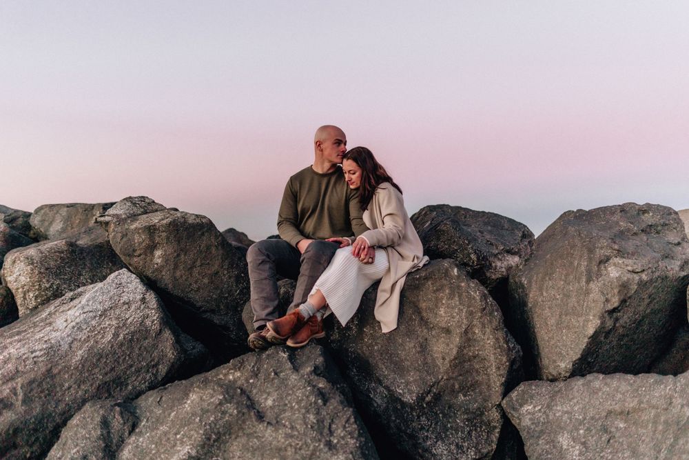 couple sitting on rocks in virginia beach, virginia beach elopement