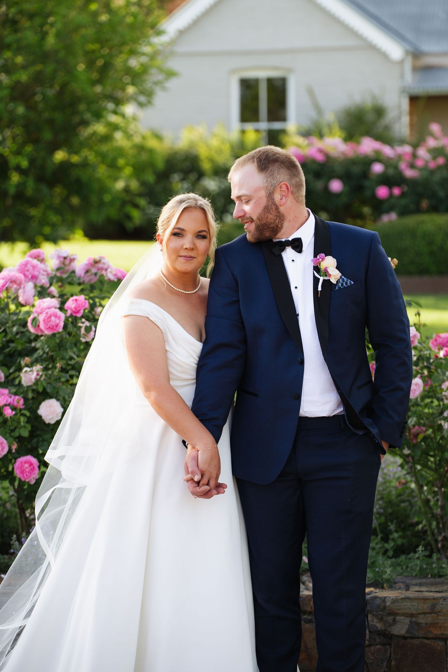bride and groom holding hands in front of rose garden at Tamworth Goonoo Goonoo country Wedding