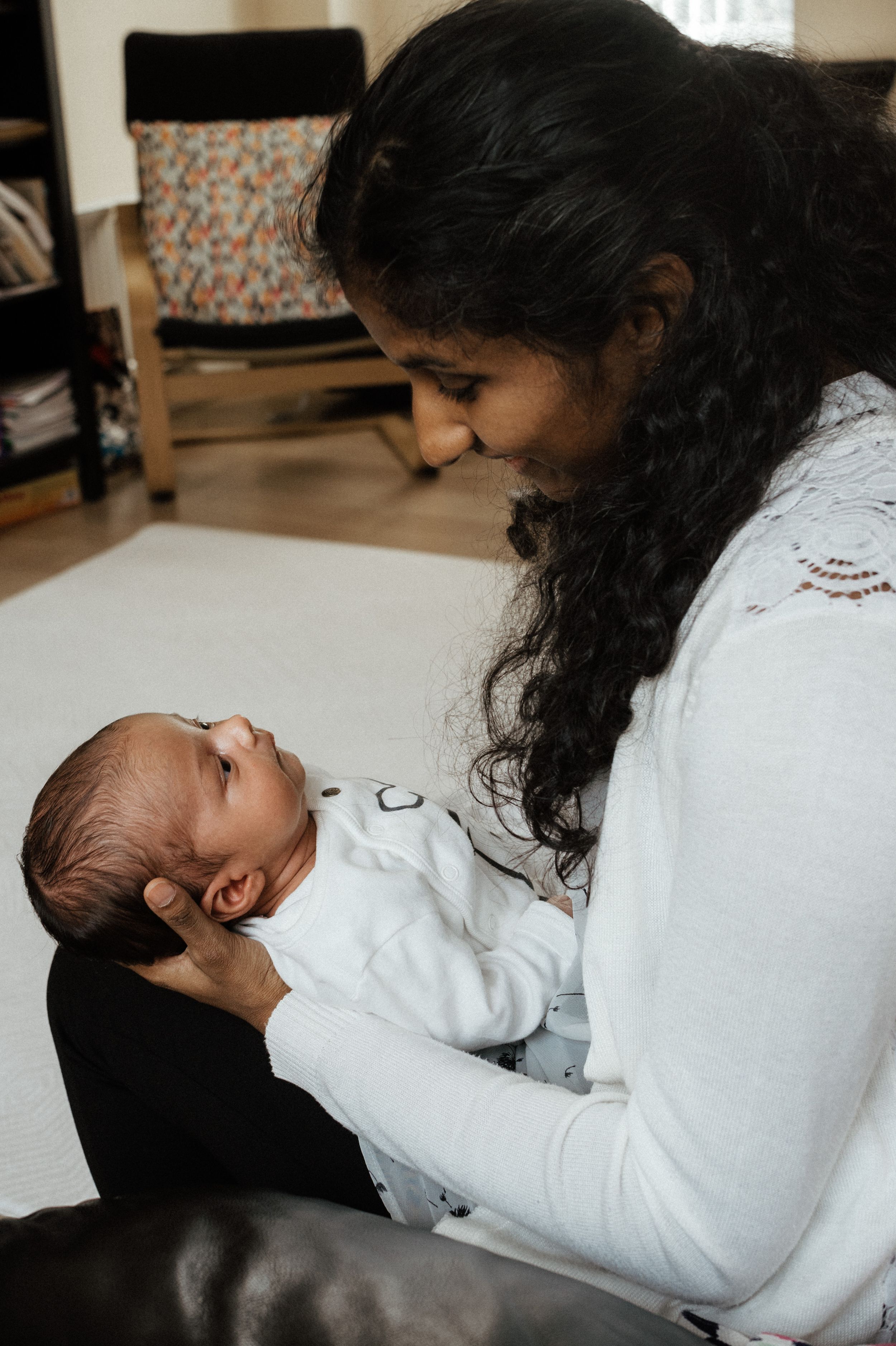 A series of intimate moments between parent and newborn in soft lighting.