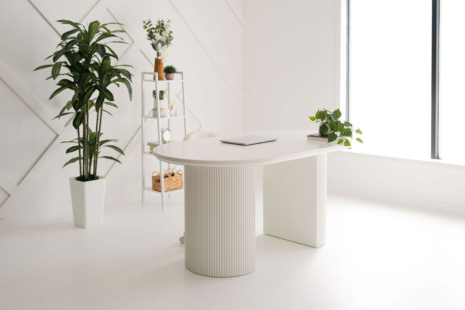 Minimalist white photography studio with seamless backdrop, natural window light, and mobile prop cart.