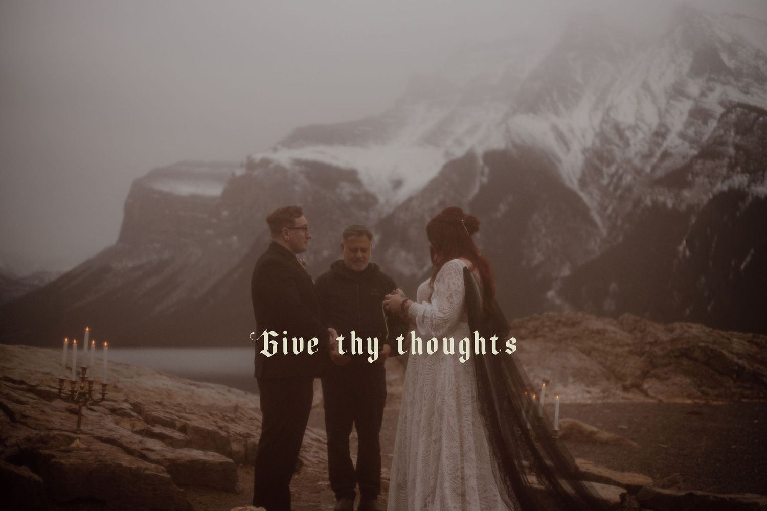 Moody shot of the bride and groom sharing vows in front of lakeside mountains during their intimate ceremony.