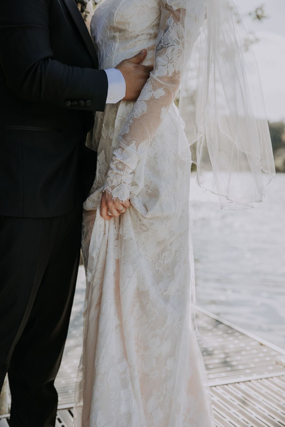 Close-up detail shots of a white lace wedding dress with long sleeves and delicate floral embellishments.