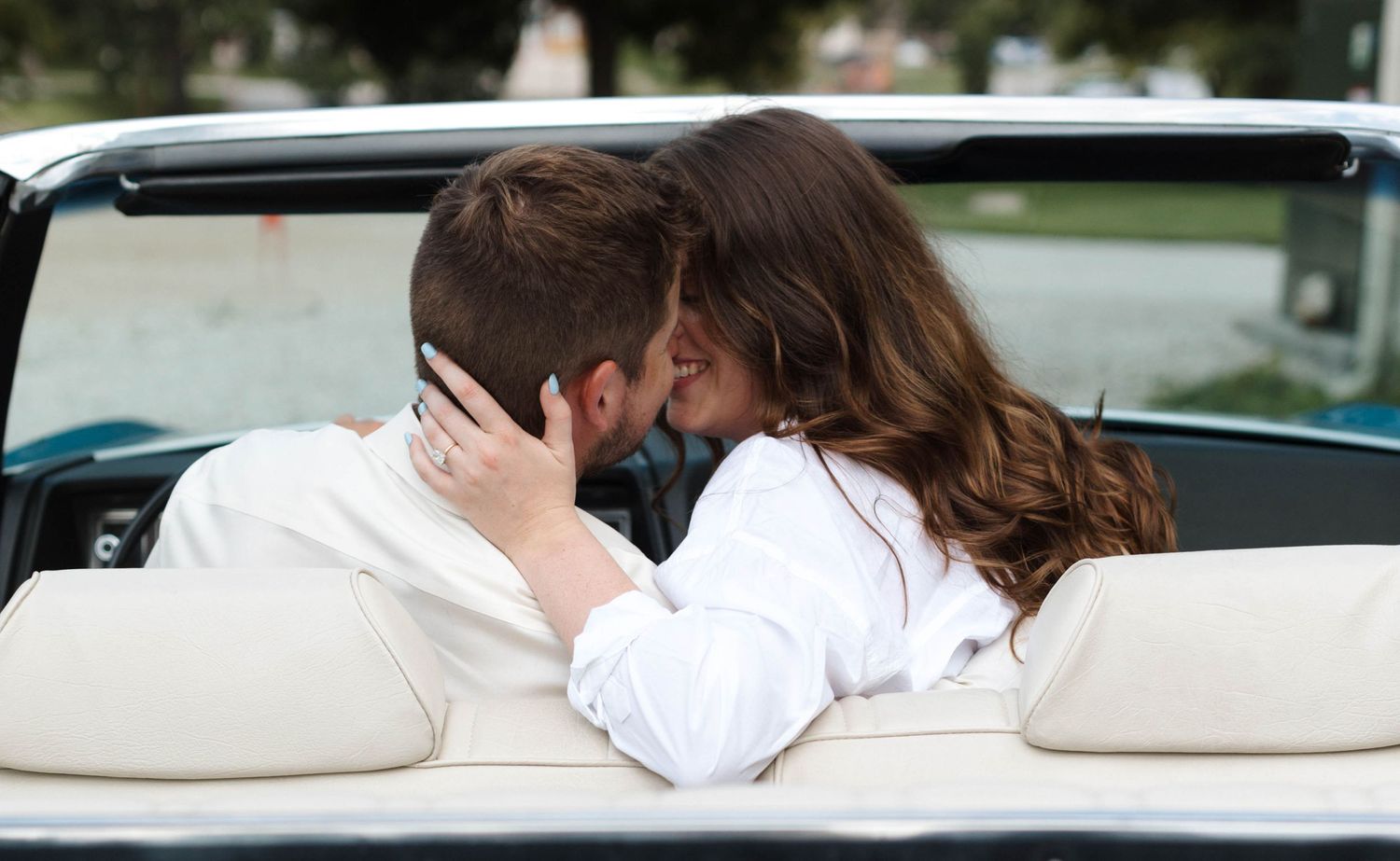 A romantic couple's photo session in a vintage car with white interior.