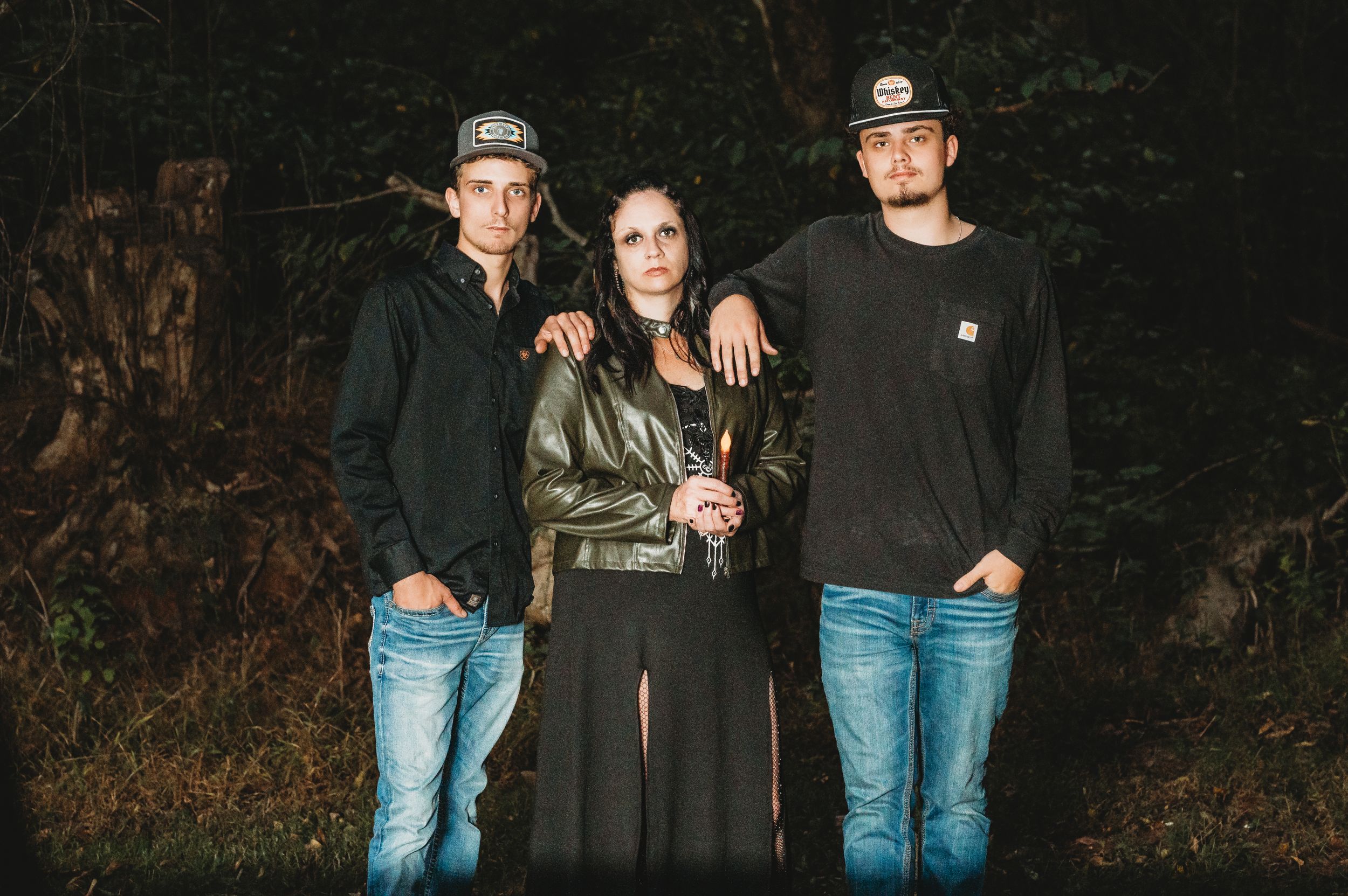 Group of people standing together outdoors in casual clothing at night.