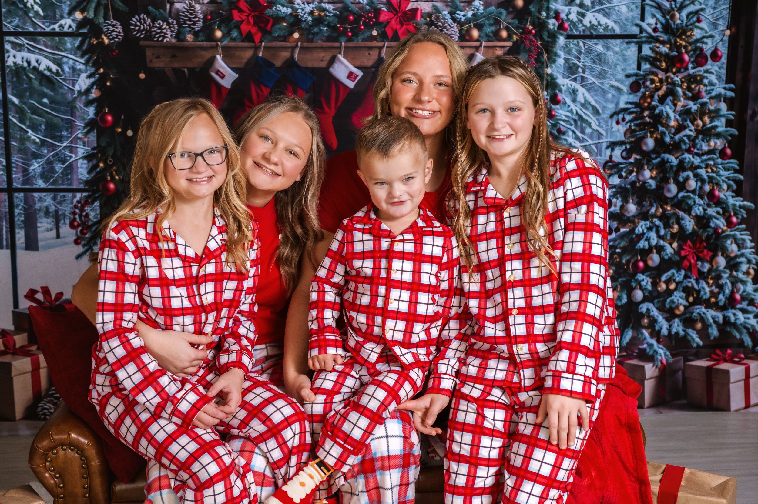Multi-generational family wearing matching red and white plaid pajamas for Christmas photos.