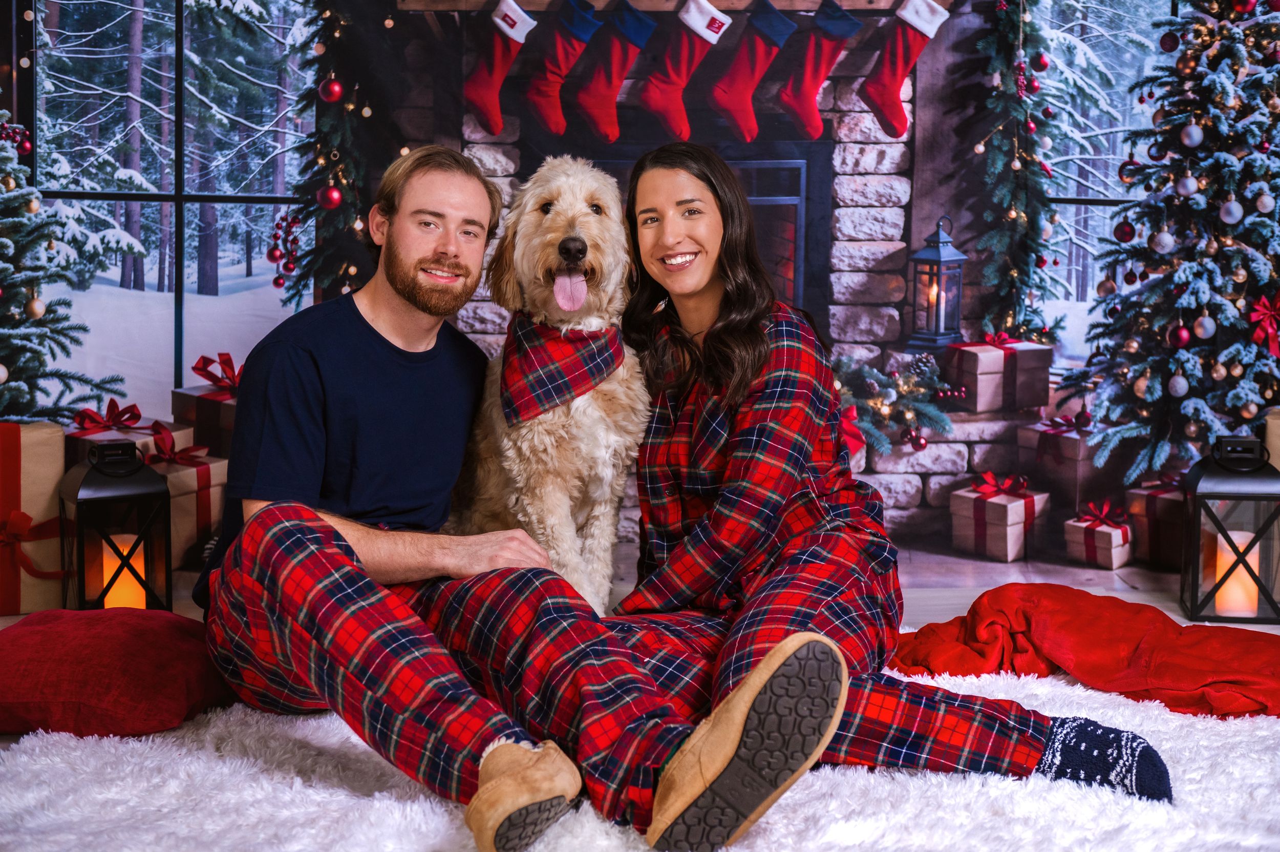 Cozy Christmas portrait with matching plaid outfits and decorated holiday background.