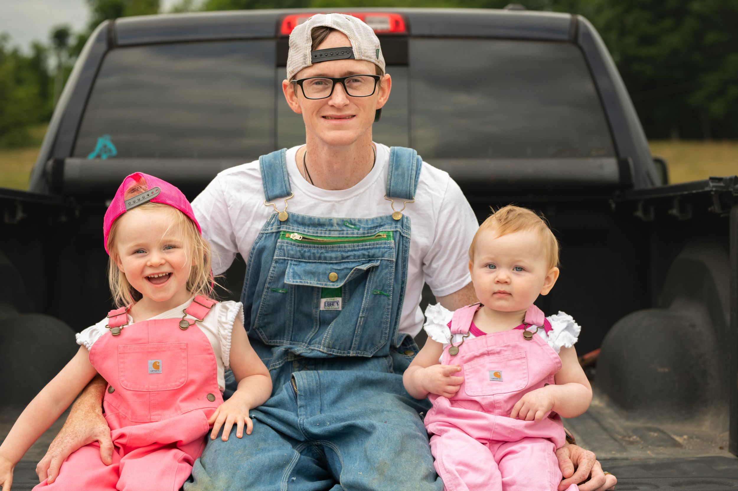 A cheerful scene of family members sitting in the bed of a pickup truck.