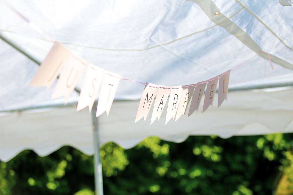 White decorative bunting hanging against bright sky at outdoor event.