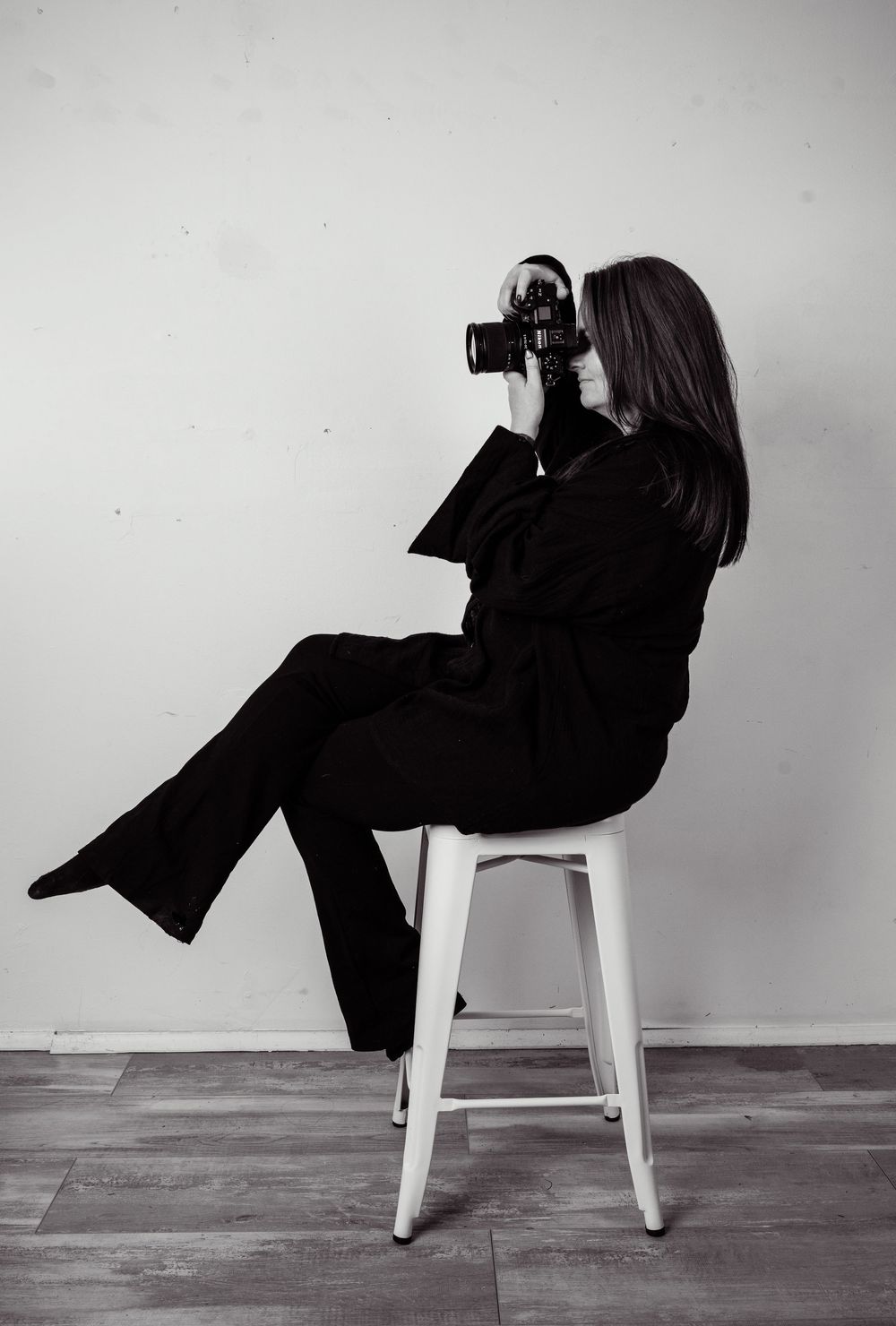 Fashion photoshoot featuring emerald green lace outfit and black boots against white studio backdrop.