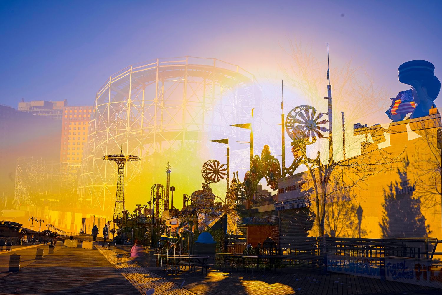 Amusement park rides and attractions glow in golden sunset light at Coney Island.