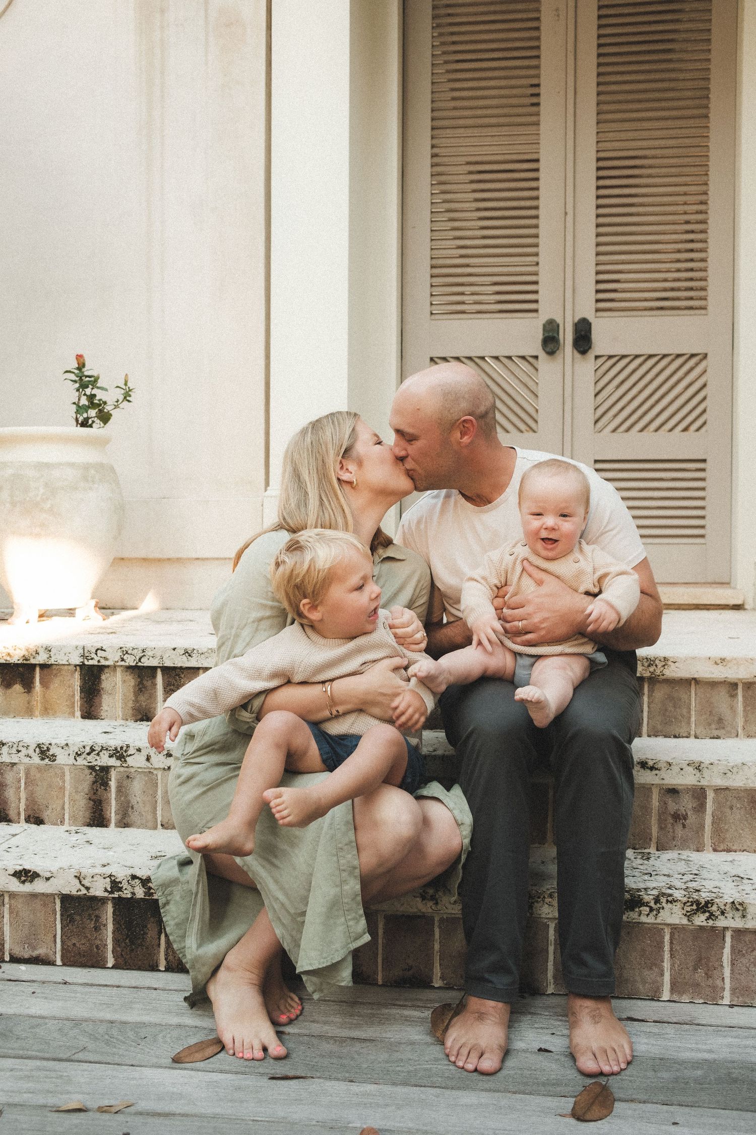 Family sitting together on concrete steps sharing intimate moments outdoors.
