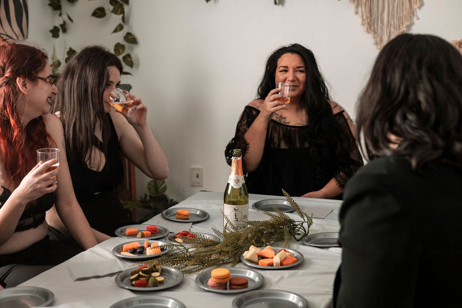 Intimate dinner party setting with dark silhouettes of people at a decorated table.