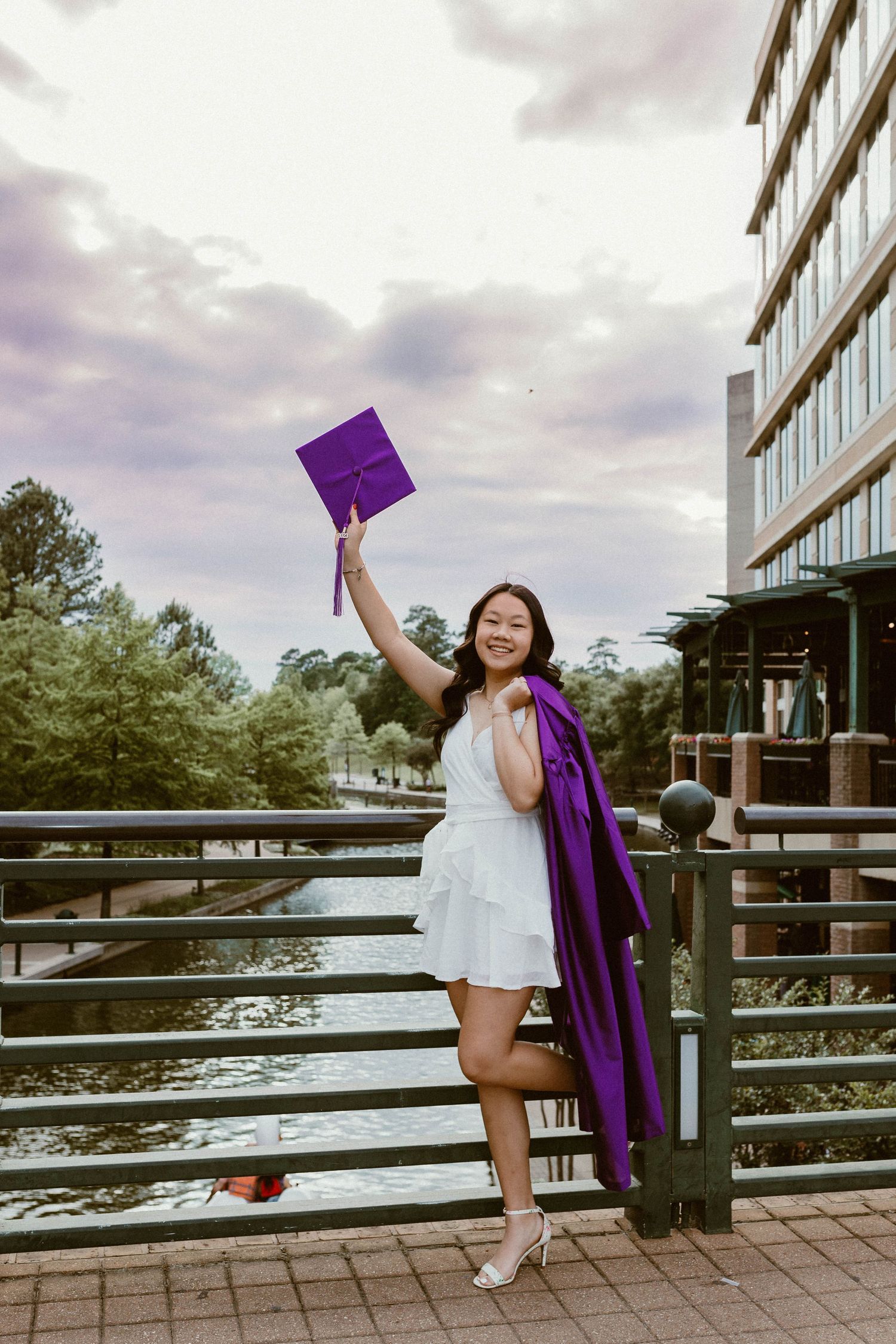 White dress-clad figure poses triumphantly in modern building doorway.
