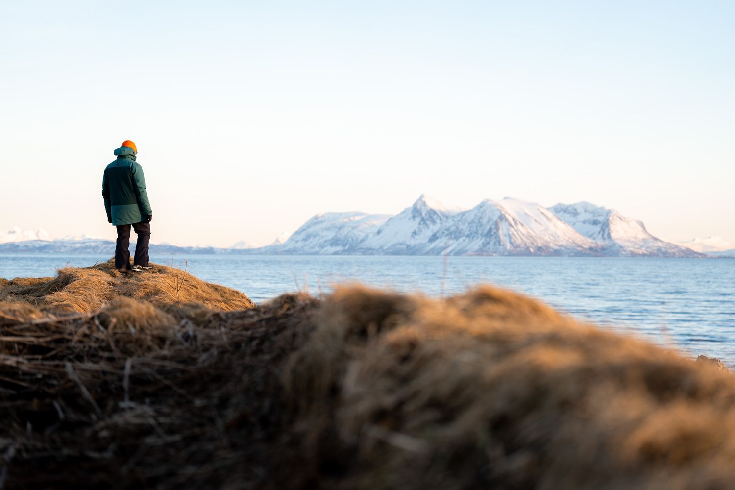 paysage des iles lofoten en norvege pendant l'hiver, randonneur avec montagnes enneigées en arrière plan