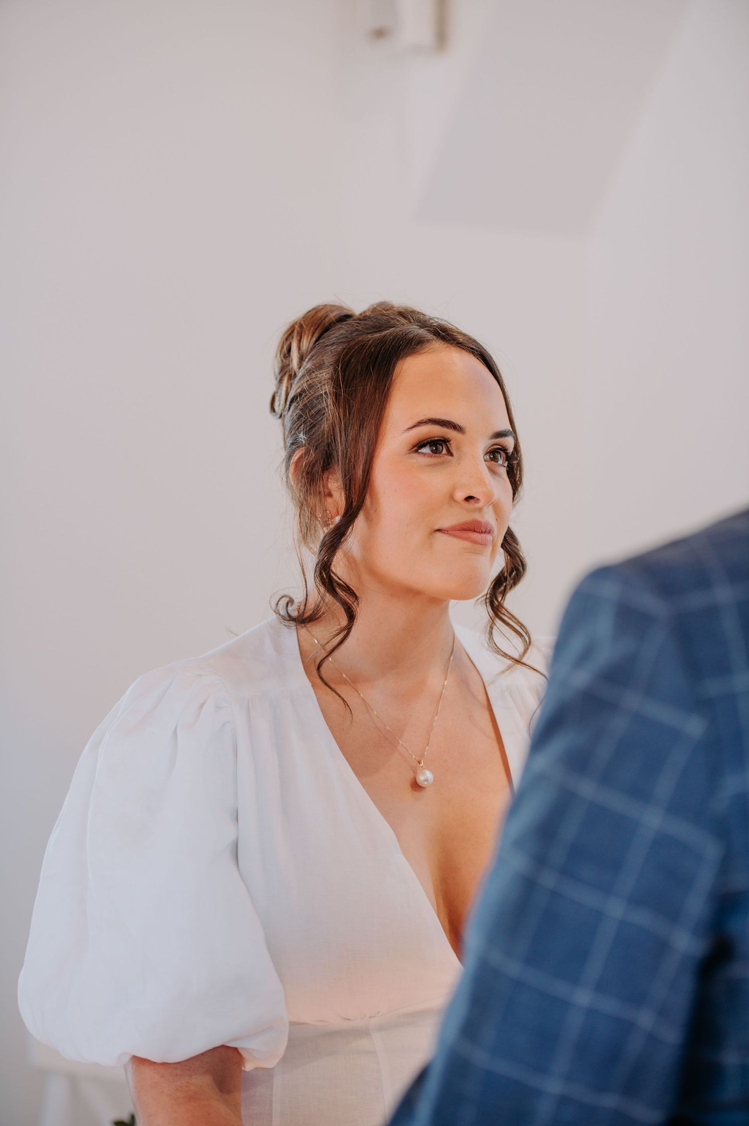 Bride in elegant white dress with puff sleeves during ceremony.