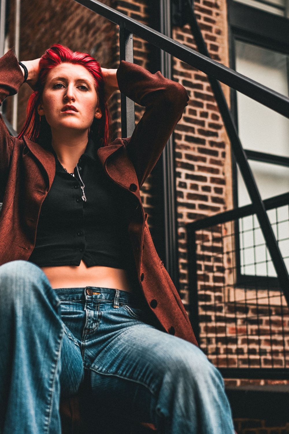 Senior girl sits on stairs in Lafayette, IN for photoshoot.
