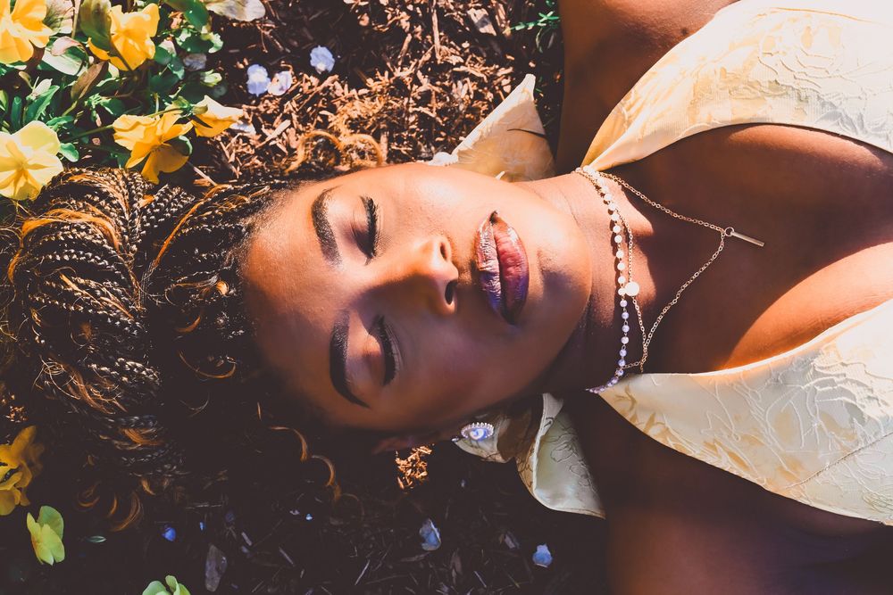 Purdue Graduate laying on grass at Purdue University.