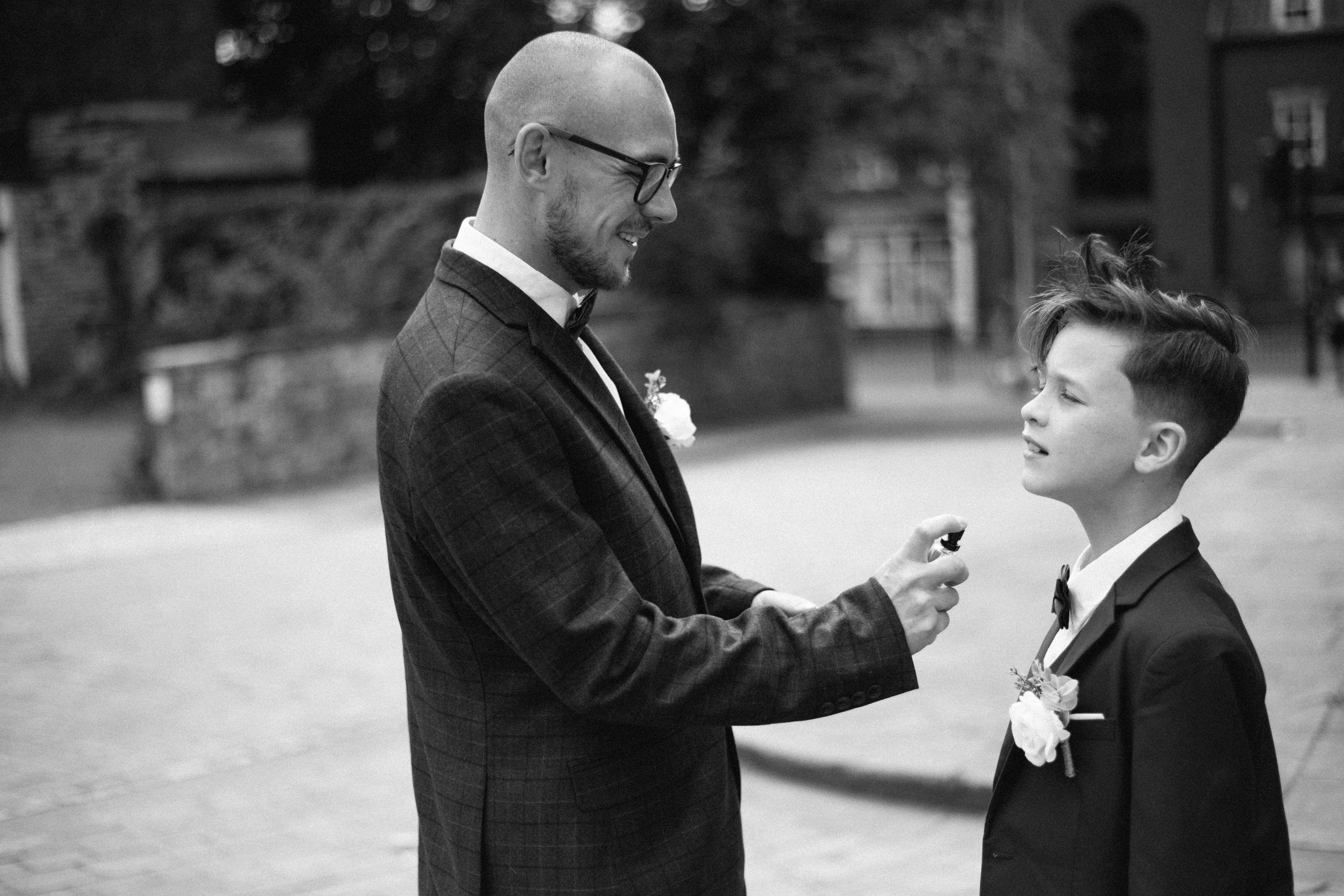 Black and white photo of formal attire adjustment outdoors.