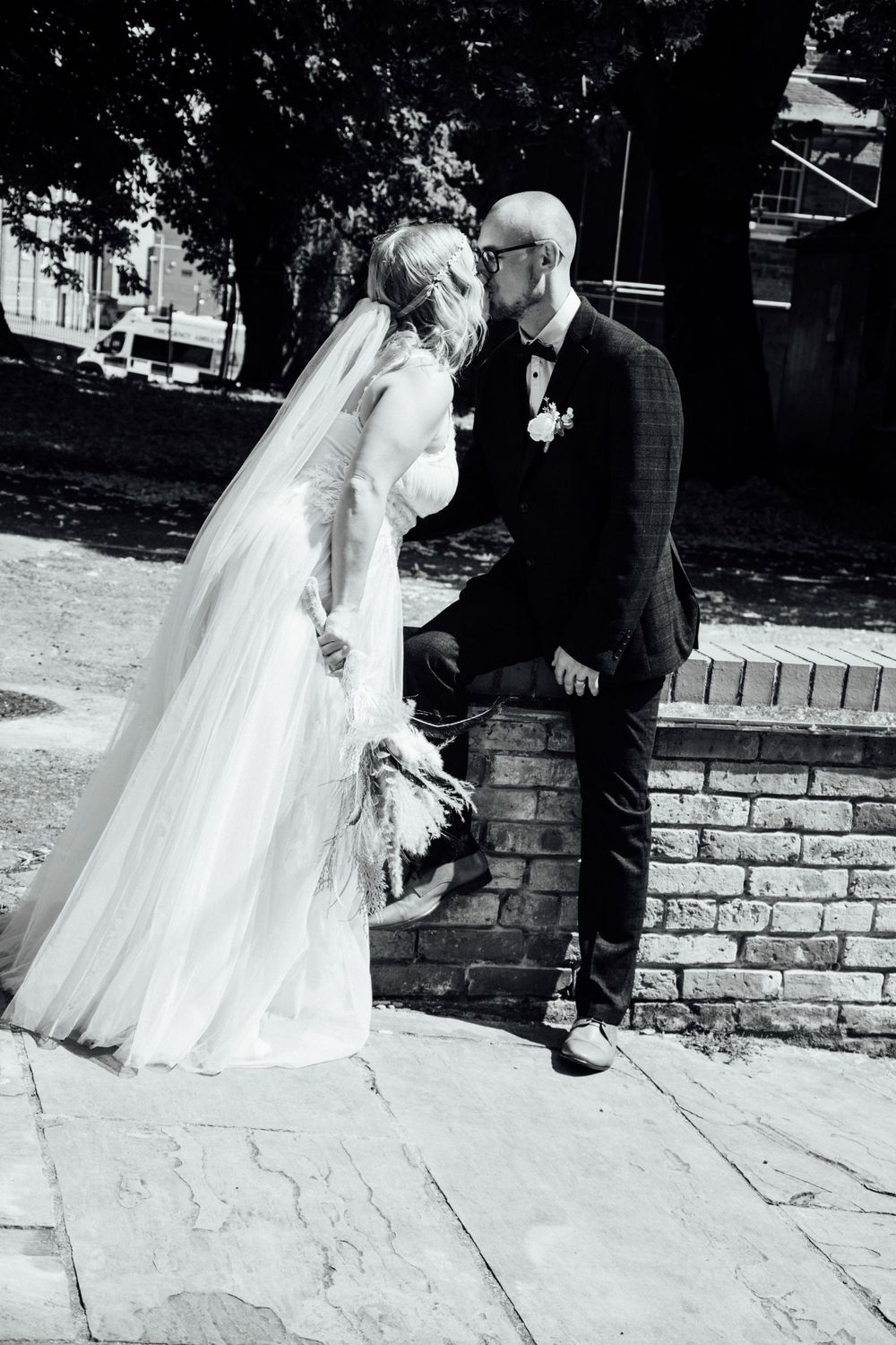 A romantic black and white wedding portrait on a brick walkway.