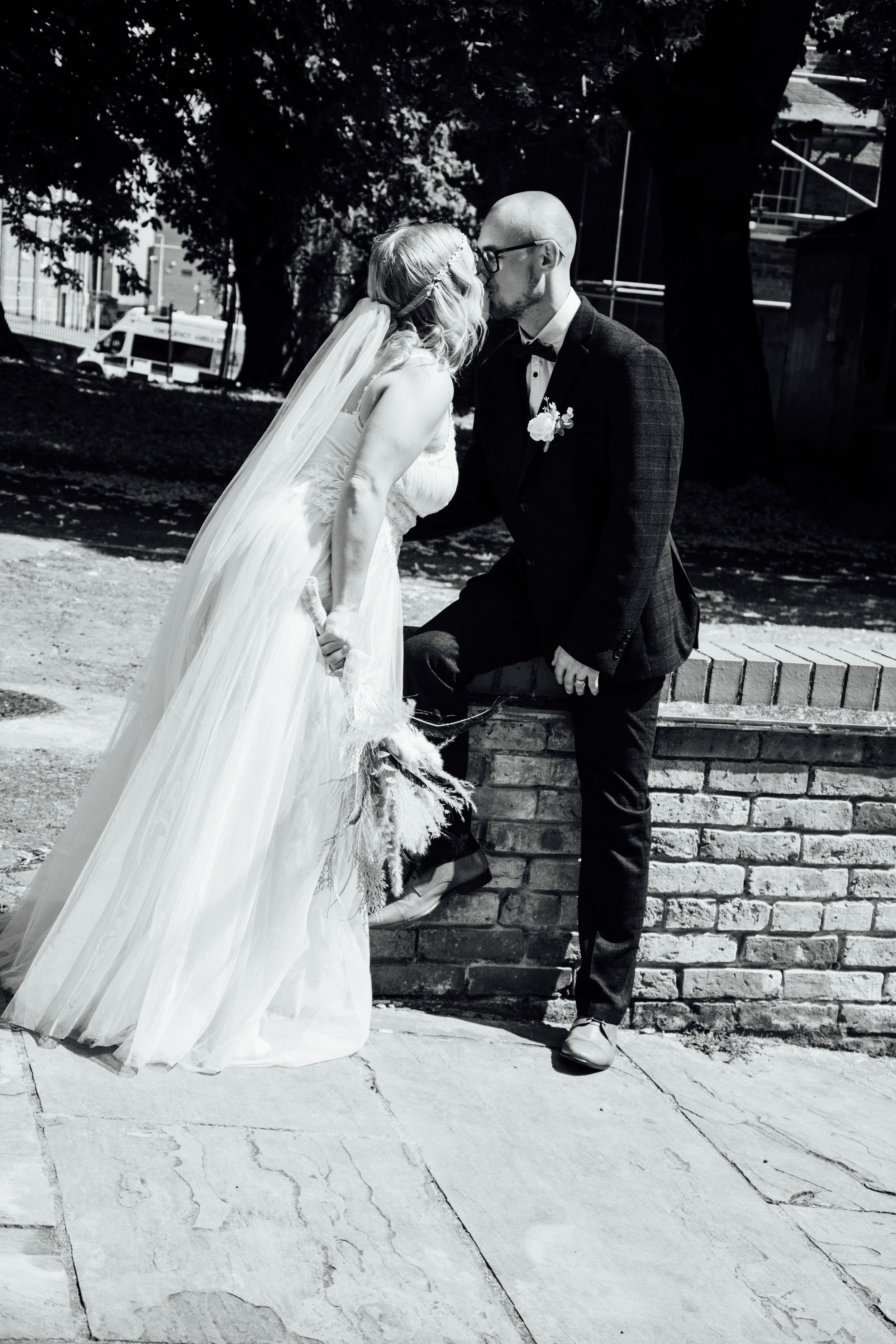 A romantic black and white wedding portrait on a brick walkway.