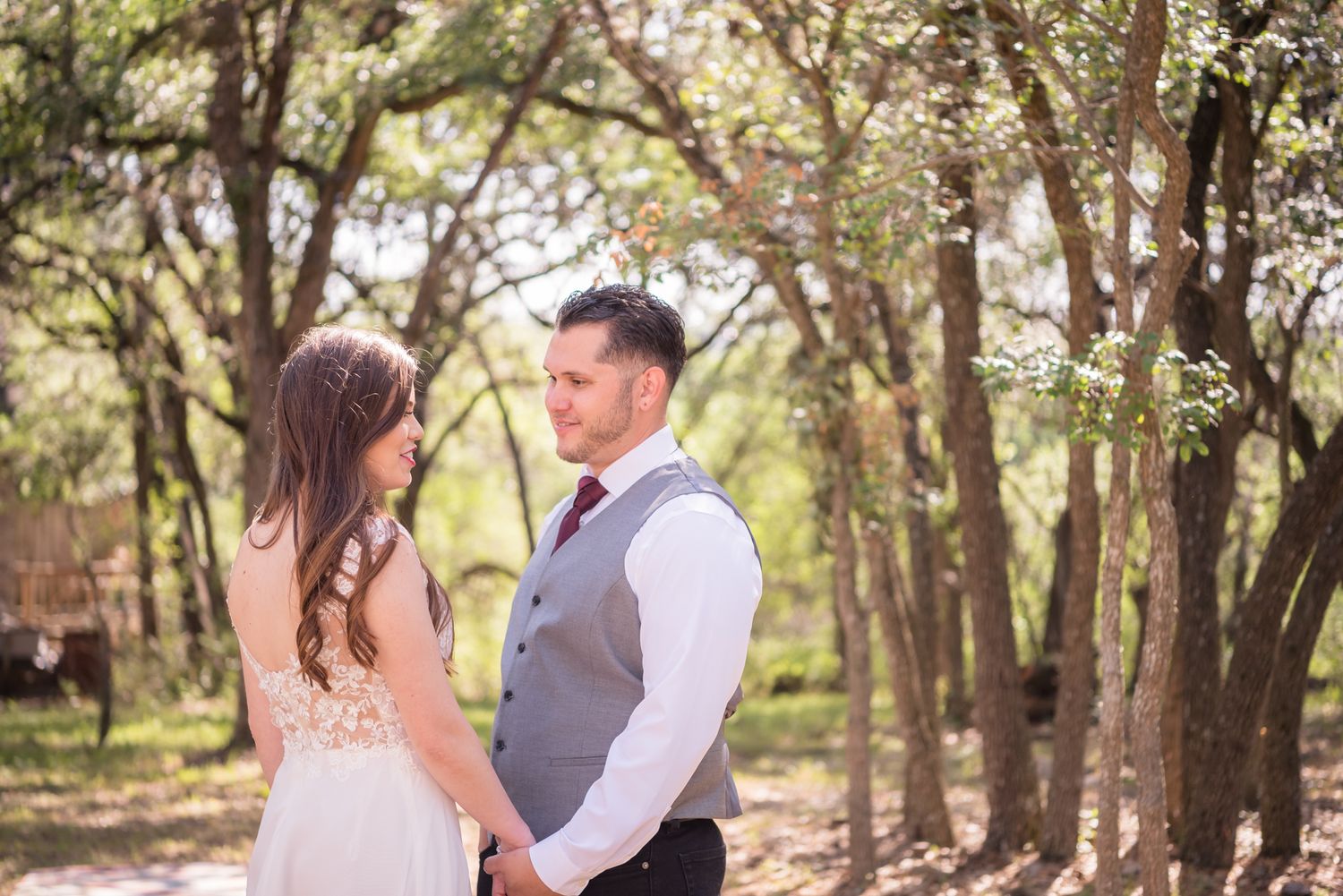 Couple shares intimate moment during woodland wedding photoshoot.
