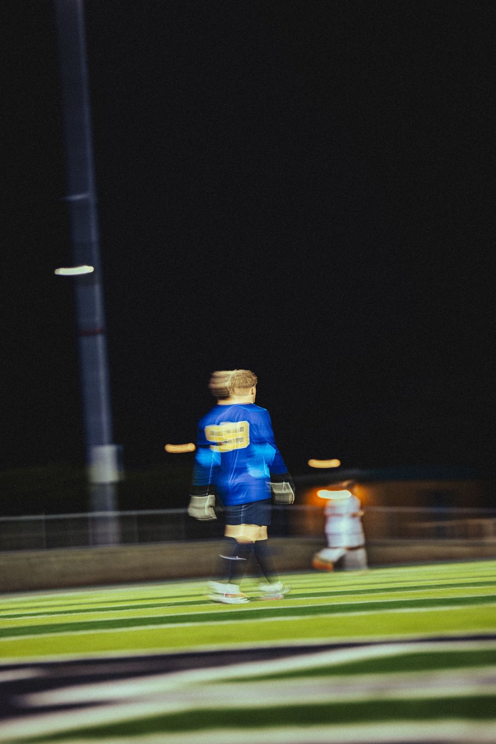 Motion blur sequence of a LEGO minifigure running across a green surface against a dark background.