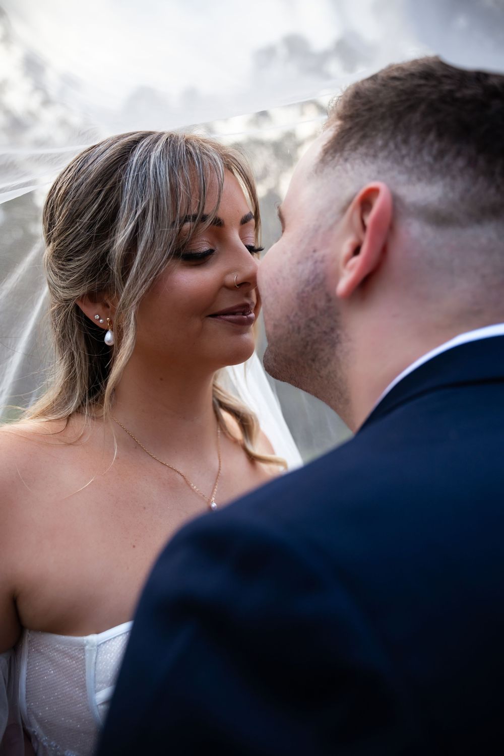 Intimate wedding moment captured in soft natural light during sunset.