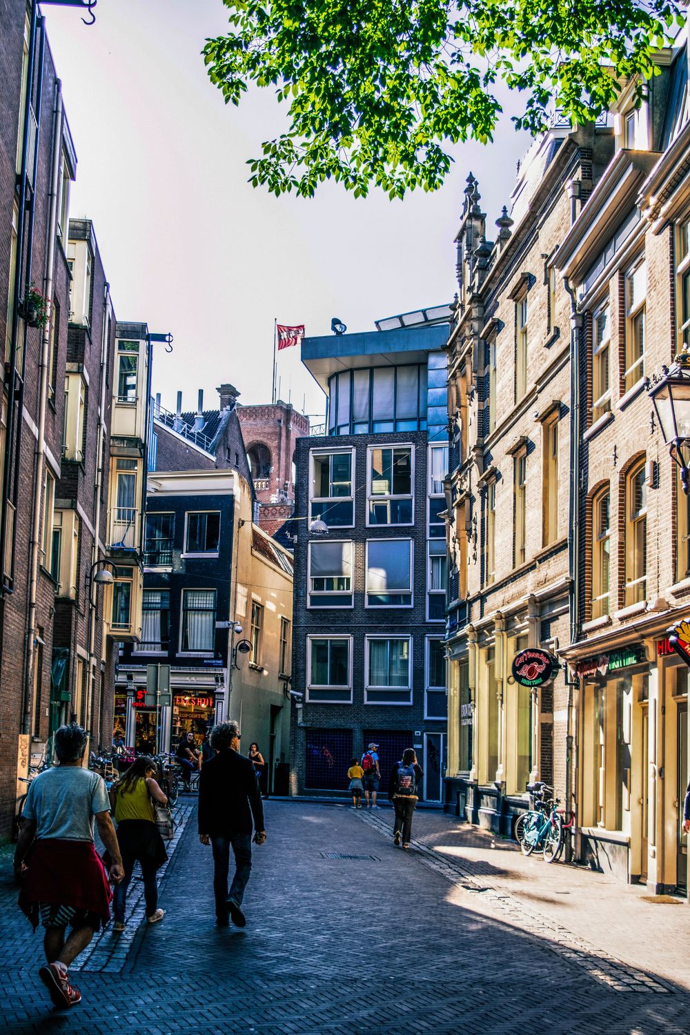 Narrow alley in Amsterdam showcasing colorful traditional Dutch architecture and bicycles.