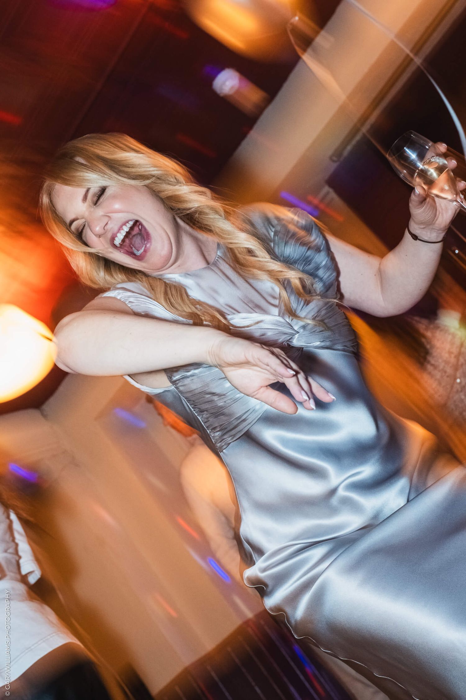 Birthday girl caught dancing with a glass of champagne.