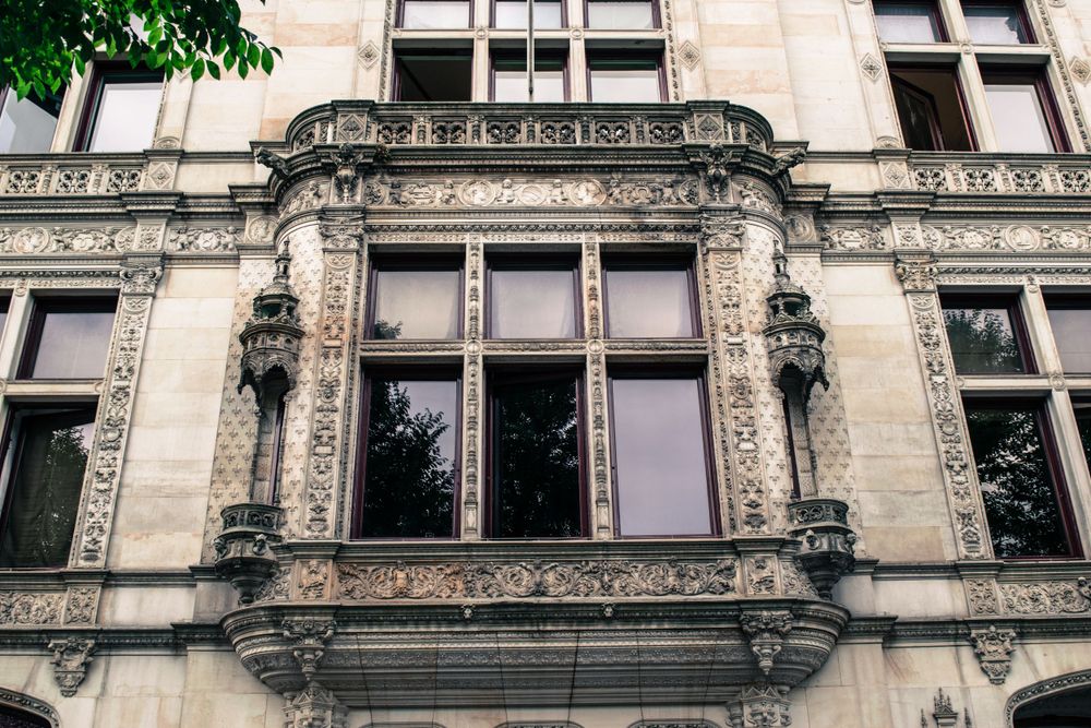 Ornate decorative stone window frame with detailed architectural carvings on a historic building facade.