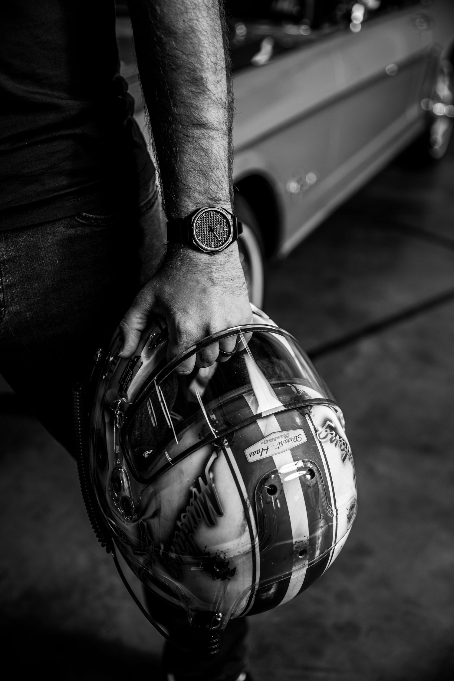 Black and white close-up shots of hands holding a football helmet from different angles.